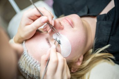 Güzellik salonunda kirpik uzatma prosedürü. Kırbaçlar yakın. Spa kirpiklerini kavra. 
