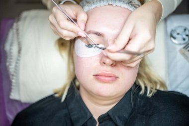 Güzellik salonunda kirpik uzatma prosedürü. Kırbaçlar yakın. Spa kirpiklerini kavra. 