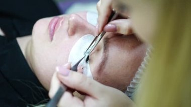 Güzellik salonunda kirpik uzatma prosedürü. Kırbaçlar yakın. Spa kirpiklerini kavra. 