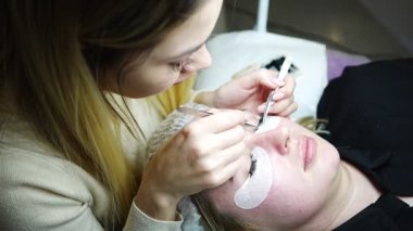 Güzellik salonunda kirpik uzatma prosedürü. Kırbaçlar yakın. Spa kirpiklerini kavra. 