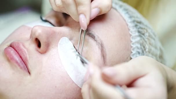 Procédure d'extension des cils dans le salon de beauté. Les cils se rapprochent. Concept cils spa. — Video