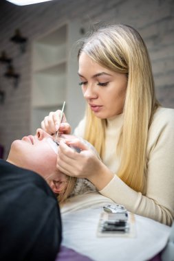 Güzellik salonunda kirpik uzatma prosedürü. Kırbaçlar yakın. Spa kirpiklerini kavra. 