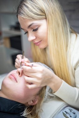 Güzellik salonunda kirpik uzatma prosedürü. Kırbaçlar yakın. Spa kirpiklerini kavra. 