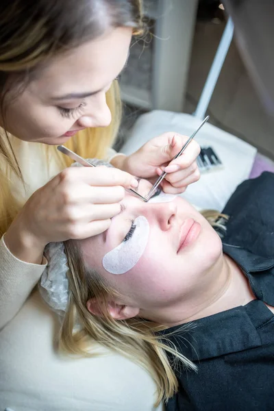 Güzellik salonunda kirpik uzatma prosedürü. Kırbaçlar yakın. Spa kirpiklerini kavra. 