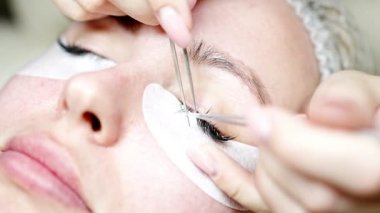 Güzellik salonunda kirpik uzatma prosedürü. Kırbaçlar yakın. Spa kirpiklerini kavra. 