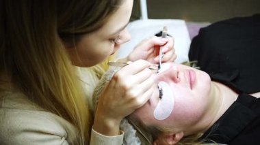 Güzellik salonunda kirpik uzatma prosedürü. Kırbaçlar yakın. Spa kirpiklerini kavra. 