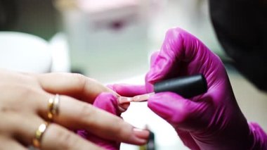 Manikür sanatçısı güzellik salonunda profesyonel manikür yapıyor.