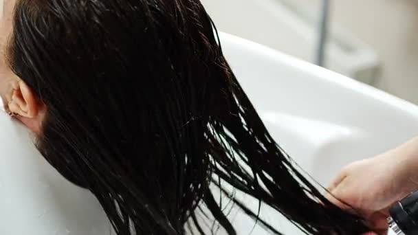 Vista de cerca del lavado del cabello en el lavabo en el salón de belleza — Vídeos de Stock