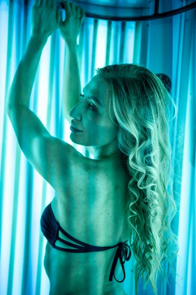 Solaryum spa salonunda bikinili sağlıklı vücutlu güzel bir kadın.