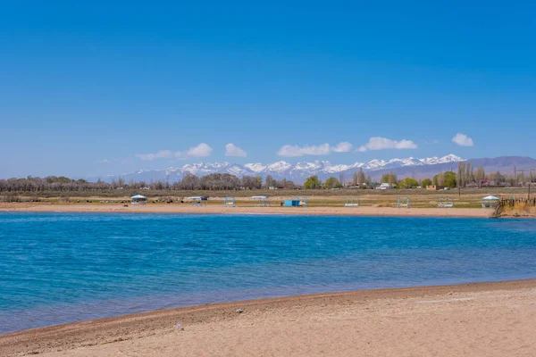 Issyk-Kul Lake est le deuxième plus grand lac de montagne au monde au Kirghizistan par une journée ensoleillée de printemps. — Photo