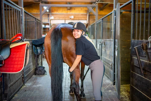 Urocza Młoda Kobieta Kasku Głaszcząca Swojego Brązowego Konia Podczas Spędzania — Zdjęcie stockowe