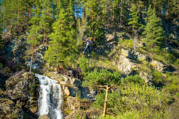 Kamysh waterfall in the Altai Republic, viewing platforms and a platform for descent on a cable rope. High quality photo
