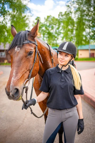 Urocza Młoda Kobieta Kasku Głaszcząca Swojego Brązowego Konia Wysokiej Jakości — Zdjęcie stockowe