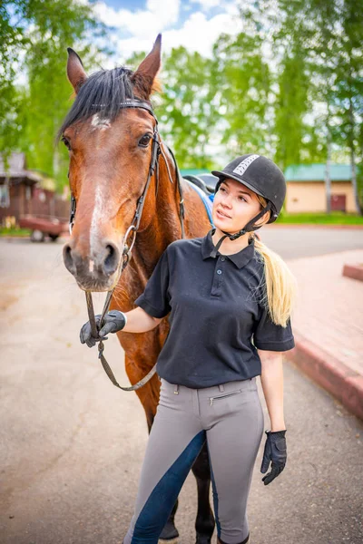 Urocza Młoda Kobieta Kasku Głaszcząca Swojego Brązowego Konia Wysokiej Jakości — Zdjęcie stockowe