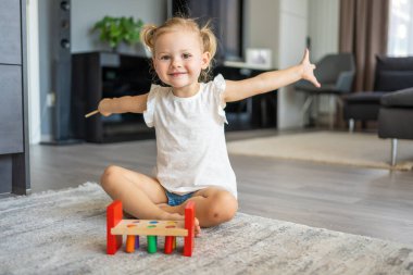 Beyaz, sevimli bir kız. Evinde yerde eko tahta oyuncaklarla oynuyor. Montessori oyuncağı. Eğitici oyunlar oynayan çocuk. Yüksek kalite fotoğraf