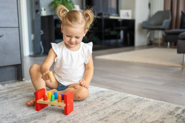 Beyaz, sevimli bir kız. Evinde yerde eko tahta oyuncaklarla oynuyor. Montessori oyuncağı. Eğitici oyunlar oynayan çocuk. Yüksek kalite fotoğraf