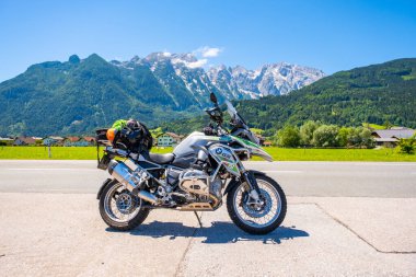 Dolomites Italy - July 2, 2022: Motorcycle with full equipment on the side of a rural mountain alpine road in area of Dolomites, Italy. High quality photo