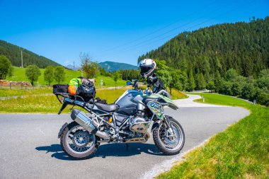 Dolomites Italy - July 2, 2022: Motorcycle with full equipment on the side of a rural mountain alpine road in area of Dolomites, Italy. High quality photo