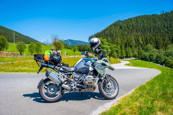 Dolomites Italy - July 2, 2022: Motorcycle with full equipment on the side of a rural mountain alpine road in area of Dolomites, Italy. High quality photo