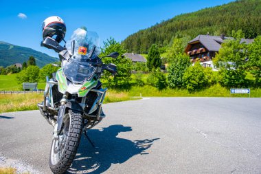 Dolomites Italy - July 2, 2022: Motorcycle with full equipment on the side of a rural mountain alpine road in area of Dolomites, Italy. High quality photo