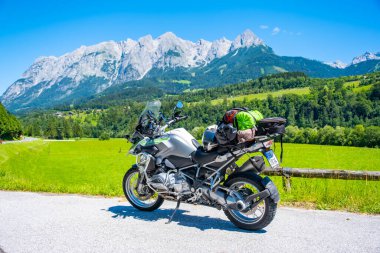 Dolomites Italy - July 2, 2022: Motorcycle with full equipment on the side of a rural mountain alpine road in area of Dolomites, Italy. High quality photo