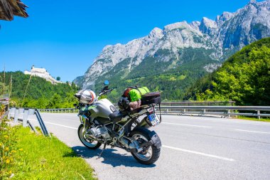 Dolomites Italy - July 2, 2022: Motorcycle with full equipment on the side of a rural mountain alpine road in area of Dolomites, Italy. High quality photo
