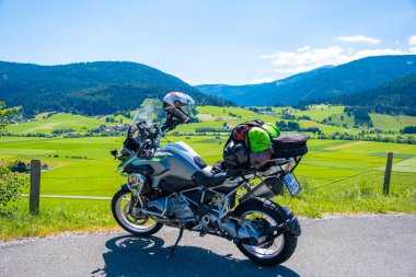 Dolomites Italy - July 2, 2022: Motorcycle with full equipment on the side of a rural mountain alpine road in area of Dolomites, Italy. High quality photo