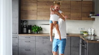 A happy father and little girl joyfully spending time in a modern kitchen. Happy family. Fathers day. High quality 4k footage