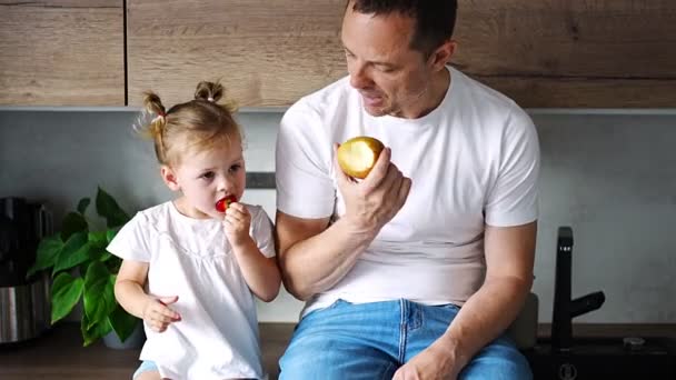 Cute Little Girl Her Handsome Dad Eating Fruit Modern Kitchen — Stockvideo