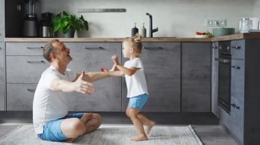 A happy father and little girl joyfully spending time in a modern kitchen. Happy family. Fathers day. High quality 4k footage