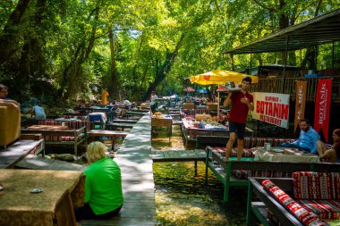 Ulupinar, Türkiye - 9 Eylül 2022: Nehirdeki tropik restoranlar. Nehir kıyısında, Türkiye 'nin ormanlarında turistlerin olduğu yerler. Yüksek kalite fotoğraf
