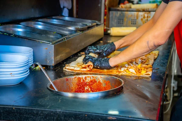 Turkish street food. Man bakes traditional griddle-cake in old town Antalya, Turkey. High quality photo