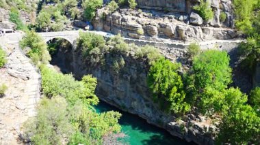 Koprucay nehir geçidi üzerindeki antik kemer köprüsü Türkiye 'deki Koprulu Milli Parkı' nda. Kanyonun panoramik manzarası ve mavi fırtınalı dağ nehri. Yüksek kalite 4k görüntü