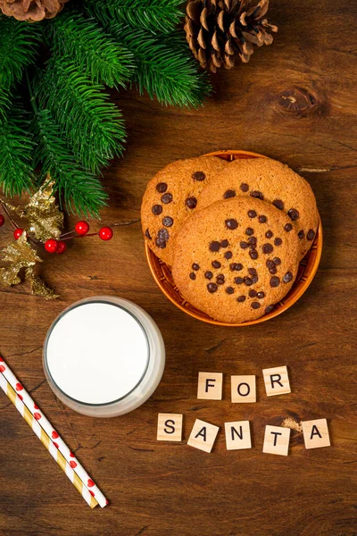 Um copo de leite e biscoitos para Papai Noel em um fundo de madeira vista superior foto vertical. Doçura de Natal para Santa — Fotografia de Stock