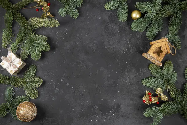 Ramas de abeto verde esponjoso, bolas de Navidad y otras decoraciones sobre el fondo gris oscuro, concepto de Navidad con espacio libre para el texto —  Fotos de Stock