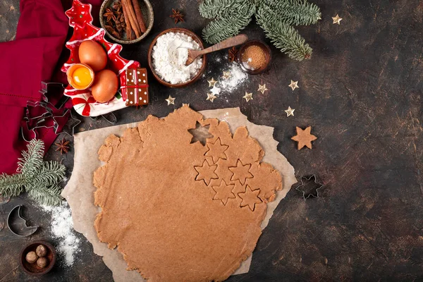Masa y productos para hacer galletas navideñas festivas. Ingredientes para galletas picantes sobre fondo oscuro, vista superior —  Fotos de Stock