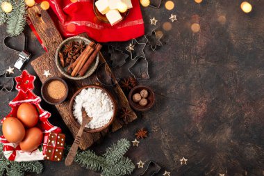 Noel kurabiyeleri yapmak için ürünler. Koyu arkaplan, üst görünüm ve metin için kopyalama alanı üzerindeki baharatlı kurabiyeler için içerikler