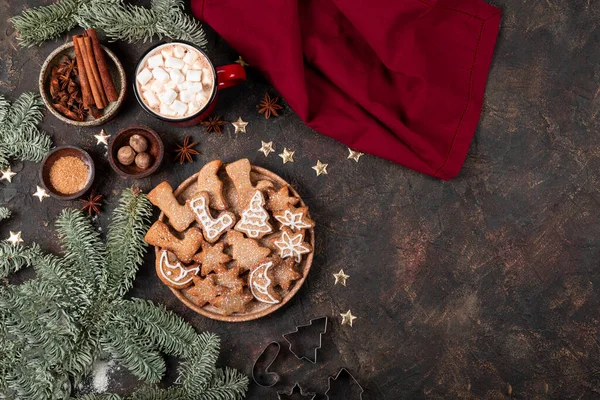 Galletas navideñas festivas decoradas con glaseado y azúcar en polvo en un plato. Fondo oscuro, vista superior, espacio de copia para texto —  Fotos de Stock