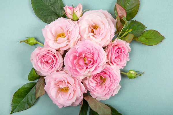 Krásné letní a jarní přání s kyticí růžových růží na moderním zeleném pozadí. Kytice růžových růží horní pohled — Stock fotografie