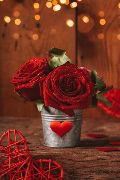 Valentines Day greeting card with free space for text. Red rose in a pot and red hearts on a wooden background vertical photo — Fotografia de Stock