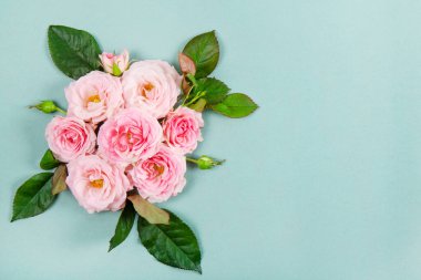 Modern yeşil arka planda pembe güllerle dolu güzel bir yaz ve bahar kartı. Bir buket pembe gül üst görünüm metin için kopyalama alanı