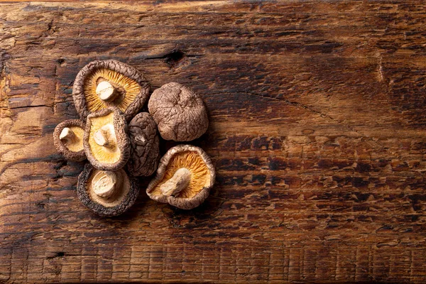 Sušené shiitake houby na dřevěném pozadí horní pohled kopírovat prostor pro text — Stock fotografie