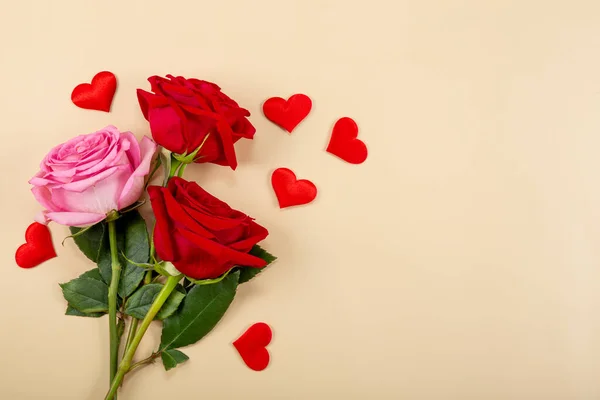 Rosenstrauß und rote Herzen auf beigem Hintergrund, Draufsicht, freier Raum für Text. Grußkarte zum Valentinstag — Stockfoto