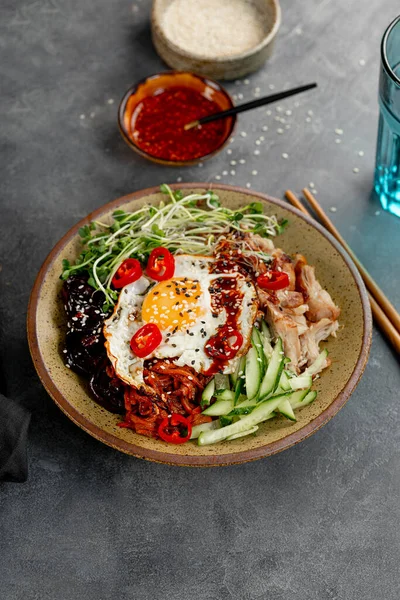 전통 한국 요리 Bibimbap. 쌀, 시타 케 버섯, 닭고기,오이, 극소량의 야채, 한국 산 비임 바프 소스를 넣어 먹는다. 어두운 배경, 수직 사진 — 스톡 사진