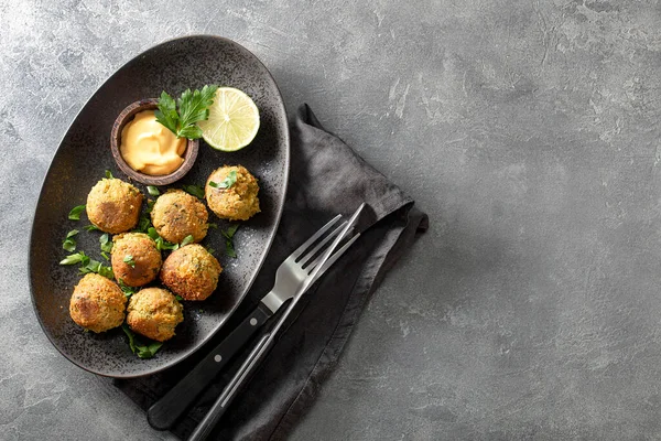 Falafel aux pois chiches avec sauce sur plaque noire et fond gris vue du dessus, espace de copie pour le texte — Photo