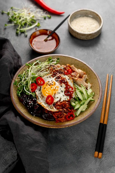 전통 한국 요리 Bibimbap. 쌀, 시타 케 버섯, 닭고기,오이, 극소량의 야채, 한국 산 비임 바프 소스를 넣어 먹는다. 어두운 배경, 수직 사진 — 스톡 사진