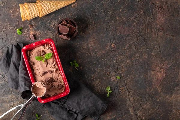 Домашнє шоколадне морозиво в мисці з шоколадом і м'ятою на темному тлі, місце для тексту зверху — стокове фото