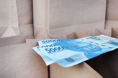 Kese kağıdının üzerinde kahverengi bir kese kağıdına sahip 50 bin rupia.