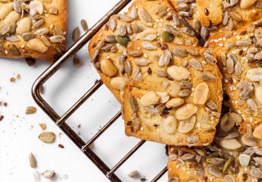 Fıstık ve tohum serpiştirilmiş karamelli kurabiyeler bir yemek tepsisinin üzerindedir. Tatlı..