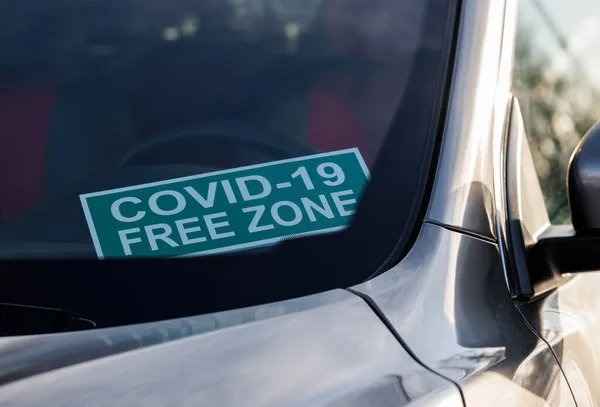 Covid-19 serbest bölge. Arabanın ön camında karton bir tabela var..